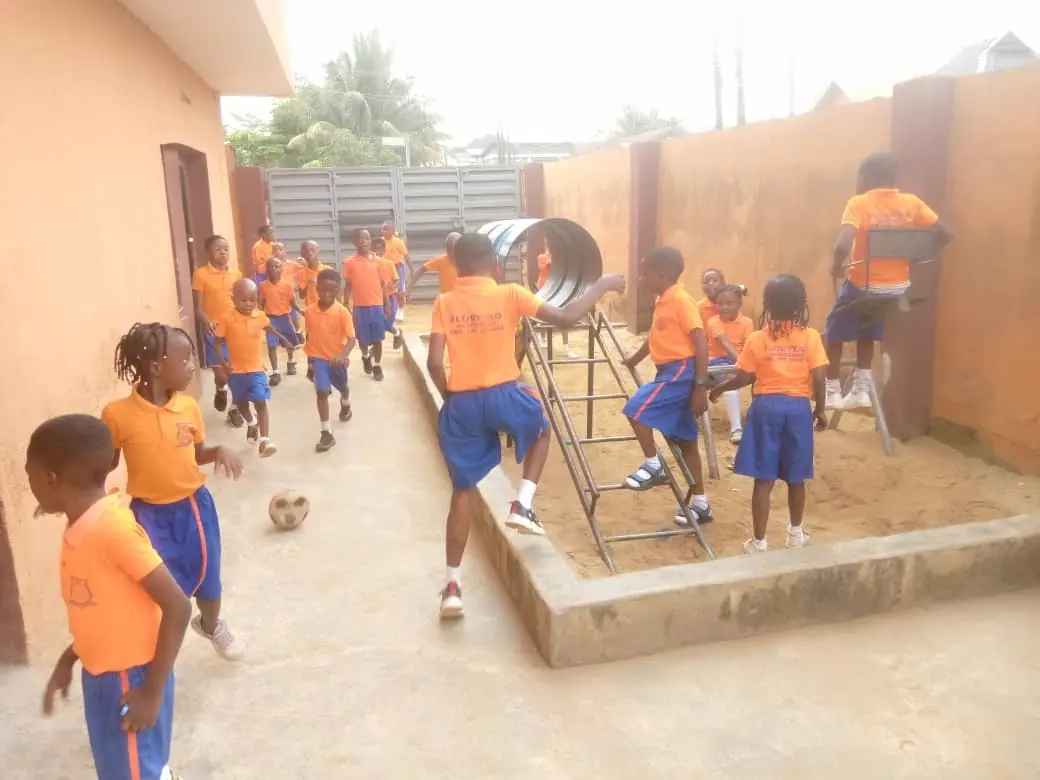 Pupils running, climbing and kicking a ball in the school playground